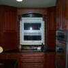 This is the baking center. Custom tambour cabinets on either side of the window tied together by a mini arch valance with small decorative corbels. 